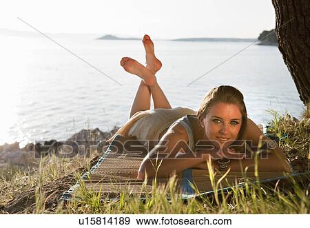 Woman lying at grassy beach View Large Photo Image Stock Photo - Woman lying at grassy beach. Fotosearch