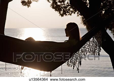 Woman lying in hammock at the beach View Large Photo Image Picture - Woman lying in hammock at the beach. Fotosearch