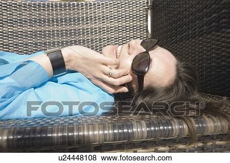 Stock Photo - Woman lying using phone. Fotosearch