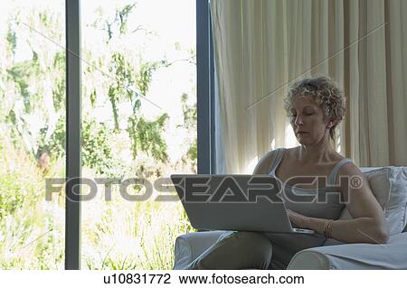 Stock Image - Woman on laptop at home. Fotosearch