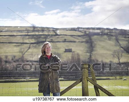 Woman posing in front of fence View Large Photo Image Stock Photo - Woman posing in front of fence. Fotosearch