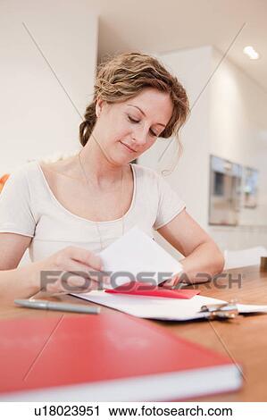 Woman putting a letter into an envelope View Large Photo Image Stock Image - Woman putting a letter into an envelope. Fotosearch