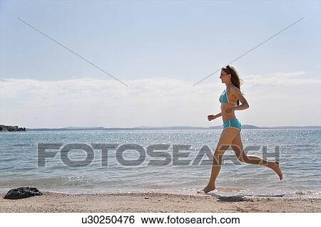 Woman running at the beach View Large Photo Image Stock Photograph - Woman running at the beach. Fotosearch