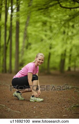 Woman running, tying laces View Large Photo Image Stock Image - Woman running, tying laces. Fotosearch
