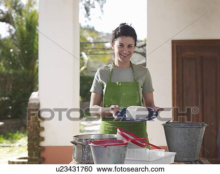 Stock Image - Woman showing freshly made goat cheese. Fotosearch
