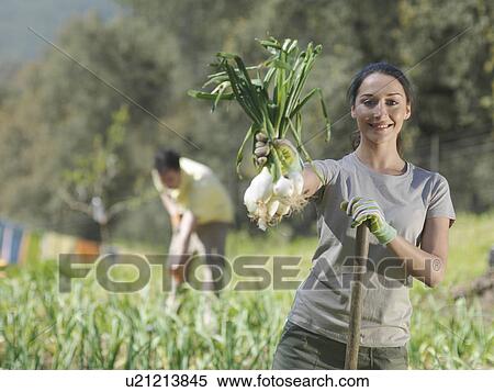 Stock Photography - Woman showing freshly picked onions. Fotosearch