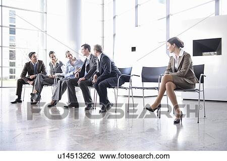 Stock Image - Woman sitting alone separate from group. Fotosearch