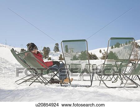 Woman sitting on chair in snowy scene View Large Photo Image Picture - Woman sitting on chair in snowy scene. Fotosearch