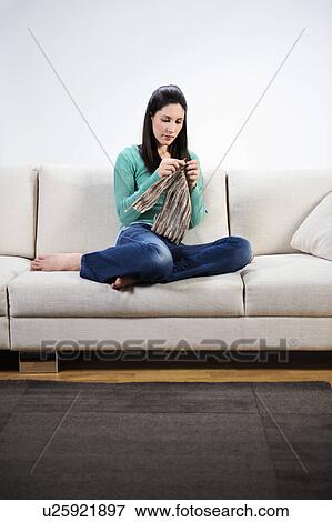 Woman sitting on couch knitting View Large Photo Image Stock Photo - Woman sitting on couch knitting. Fotosearch