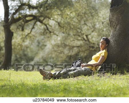Stock Photo - Woman sleeping under a tree. Fotosearch