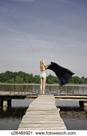Woman spreading blanket on jetty View Large Photo Image Stock Image - Woman spreading blanket on jetty. Fotosearch