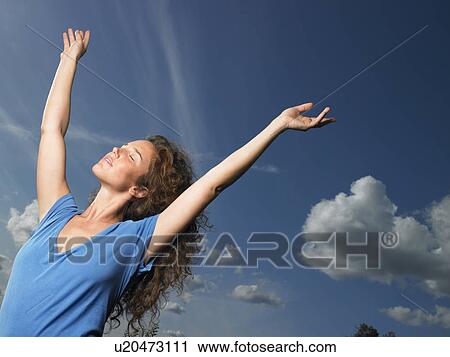 Woman spreading her arms towards the sky View Large Photo Image Stock Image - Woman spreading her arms towards the sky. Fotosearch