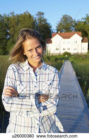 Woman standing at the end of the dock View Large Photo Image Stock Image - Woman standing at the end of the dock. Fotosearch