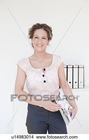 Woman standing in front of files View Large Photo Image Picture - Woman standing in front of files. Fotosearch