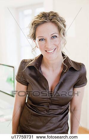 Woman standing in office smiling View Large Photo Image Stock Image - Woman standing in office smiling. Fotosearch