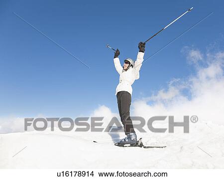 Picture - Woman standing wearing skis. Fotosearch