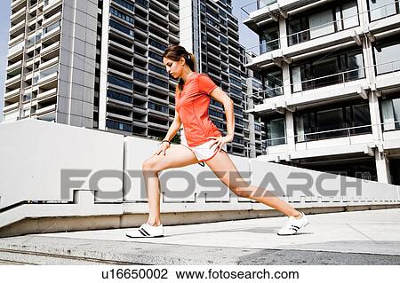 Stock Image - Woman stretching during workout. Fotosearch