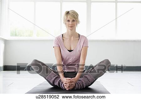 Woman stretching legs on yoga mat View Large Photo Image Stock Image - Woman stretching legs on yoga mat. Fotosearch