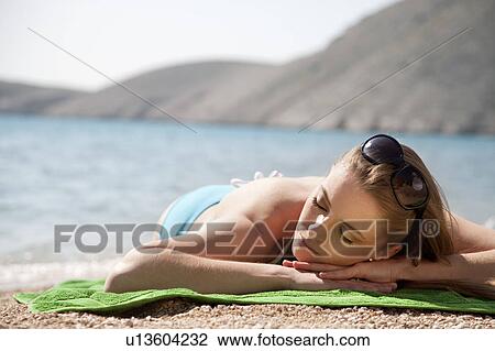 Woman sunbathing at the beach View Large Photo Image Stock Image - Woman sunbathing at the beach. Fotosearch