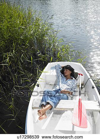 Stock Photo - Woman taking a nap in a rowboat. Fotosearch
