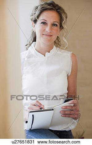 Stock Image - Woman taking notes in her diary. Fotosearch