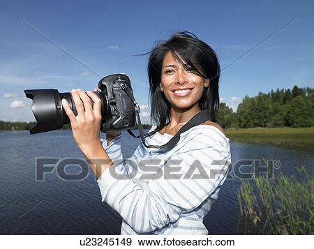 Woman taking pictures, smiling View Large Photo Image Stock Photo - Woman taking pictures, smiling. Fotosearch
