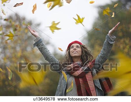 Woman throwing dried leaves into air View Large Photo Image Stock Photo - Woman throwing dried leaves into air. Fotosearch