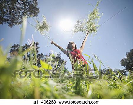 Woman throwing grass in the air View Large Photo Image Stock Photo - Woman throwing grass in the air. Fotosearch