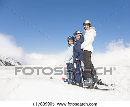 Stock Photography - Woman & Two Boys wearing skis. Fotosearch