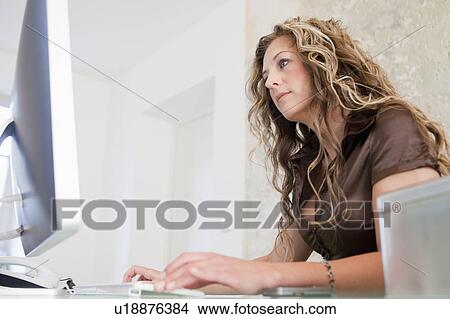 Woman typing into her computer View Large Photo Image Picture - Woman typing into her computer. Fotosearch