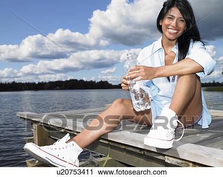 Woman with bottle of water, smiling View Large Photo Image Stock Image - Woman with bottle of water, smiling. Fotosearch