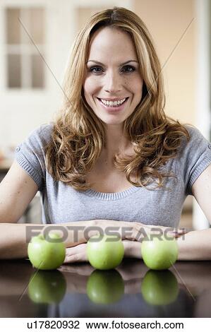 Stock Image - Woman with green apples. Fotosearch