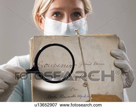 Stock Photo - Woman with magnifying glass showing file. Fotosearch