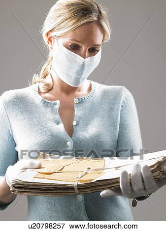 Woman with mask, holding precious files View Large Photo Image Stock Photo - Woman with mask, holding precious files. Fotosearch
