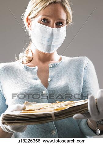 Woman with mask, holding precious files View Large Photo Image Stock Photograph - Woman with mask, holding precious files. Fotosearch