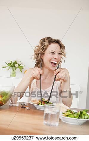 Stock Photo - Woman with mixed salad on table. Fotosearch