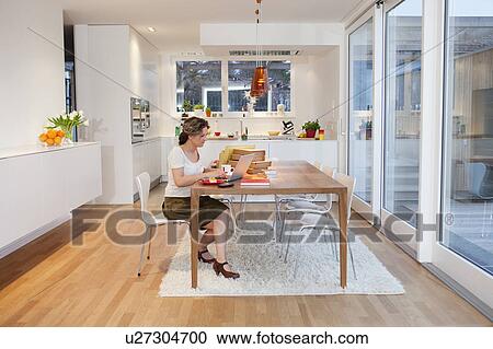 Stock Image - Woman with notebook at her home office. Fotosearch