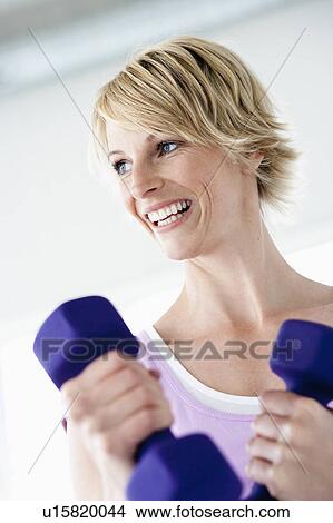 Woman with weights smiling View Large Photo Image Picture - Woman with weights smiling. Fotosearch
