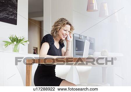 Stock Image - Woman working in home office. Fotosearch