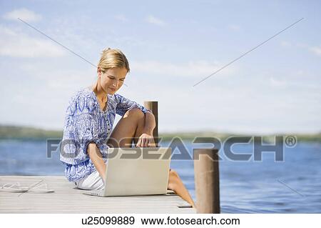 Woman working lake-side View Large Photo Image Stock Photo - Woman working lake-side. Fotosearch