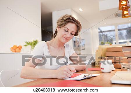 Stock Photo - Woman writing address on an envelope. Fotosearch