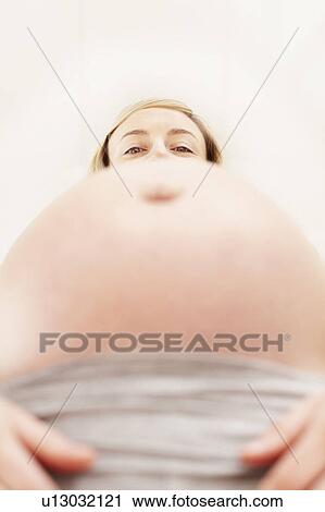 Woman's face looking over pregnant belly View Large Photo Image Stock Image - Woman's face looking over pregnant belly. Fotosearch