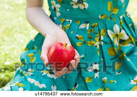 Stock Photo - Woman's hand holding apple.. Fotosearch