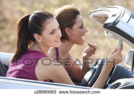 Stock Image - Women doing their make up in a car. Fotosearch