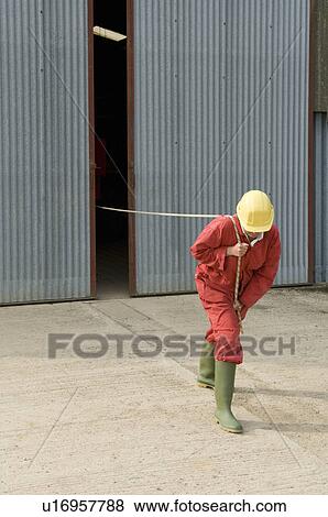 Stock Photo - Worker pulling unseen object. Fotosearch