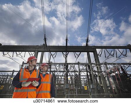 Stock Image - Workers At Electrical Switching Station. Fotosearch