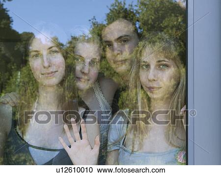 Young adults looking through glass door View Large Photo Image Stock Image - Young adults looking through glass door. Fotosearch