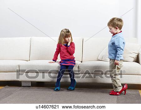 Stock Image - Young boy and girl walking in high-heels. Fotosearch