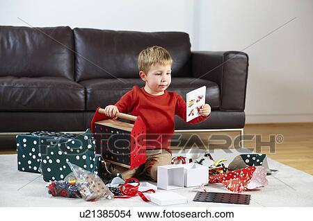 Young boy opening presents View Large Photo Image Picture - Young boy opening presents. Fotosearch