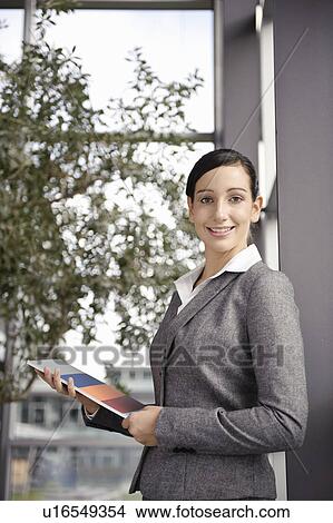 Young businesswoman looking at brochure View Large Photo Image Picture - Young businesswoman looking at brochure. Fotosearch